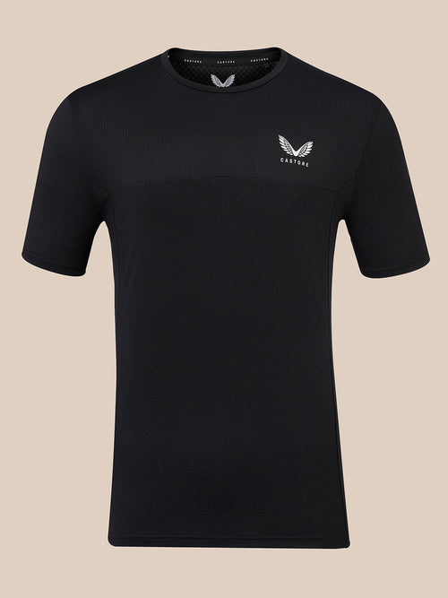 A black short-sleeve athletic t-shirt with a textured knit pattern, featuring a small white wing logo and the brand name 'CASTORE' on the left chest, displayed against a solid beige background.