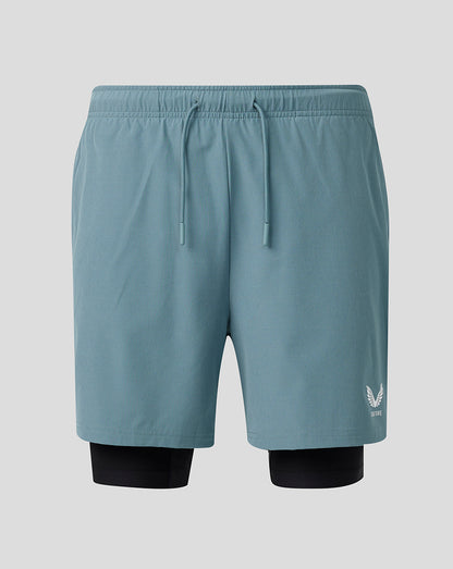 Light blue athletic shorts with a logo on a gray background