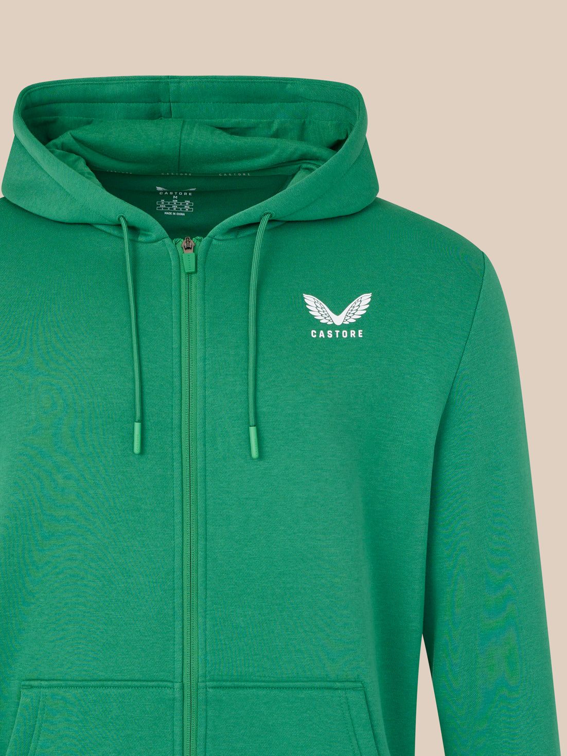 Green hoodie with a logo on a beige background