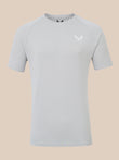 A light gray short-sleeve athletic t-shirt with a small white wing logo and the brand name 'CASTORE' printed on the left chest, displayed against a solid beige background.