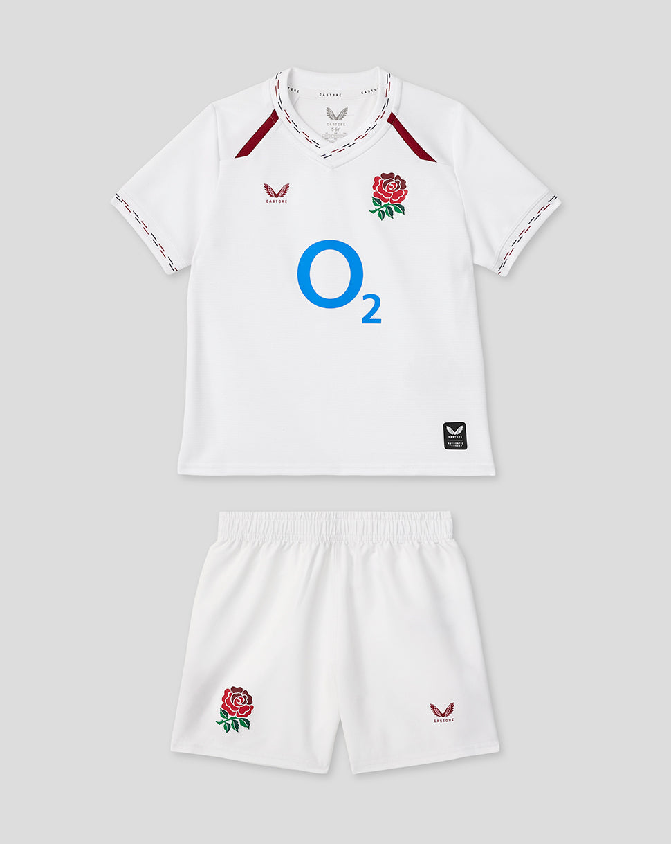 Infant white home rugby kit laid out with jersey featuring a rose crest and O2 logo and matching shorts.