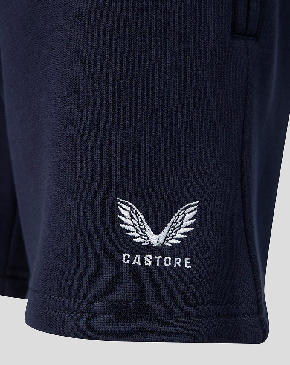 Close-up of navy travel shorts with white Castore wing logo near the hem
