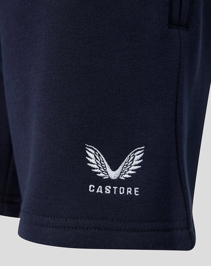 Close-up of navy travel shorts with white Castore wing logo near the hem