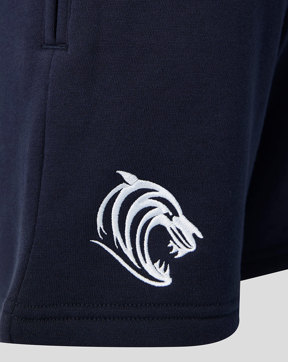 Close up of a white tiger head logo on the navy shorts at the lower left hem.
