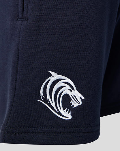 Close up of a white tiger head logo on the navy shorts at the lower left hem.