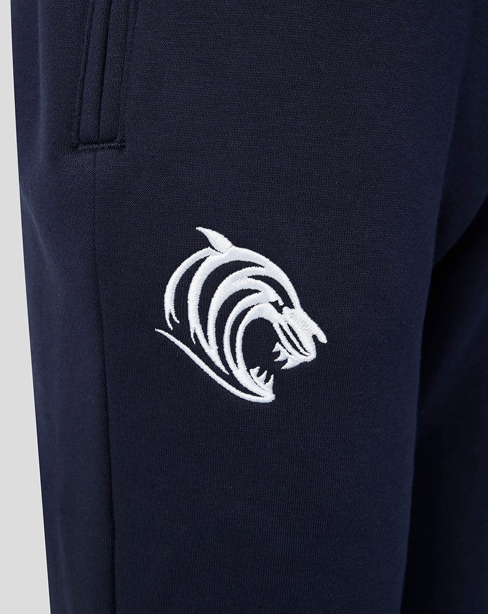 Close up of navy Adapt fleece travel joggers with a white embroidered tiger logo near the pocket.