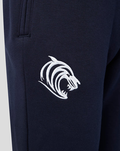 Close up of navy Adapt fleece travel joggers with a white embroidered tiger logo near the pocket.