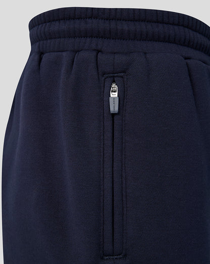 Close up of the side zip pocket on navy joggers with a Castore zipper pull.