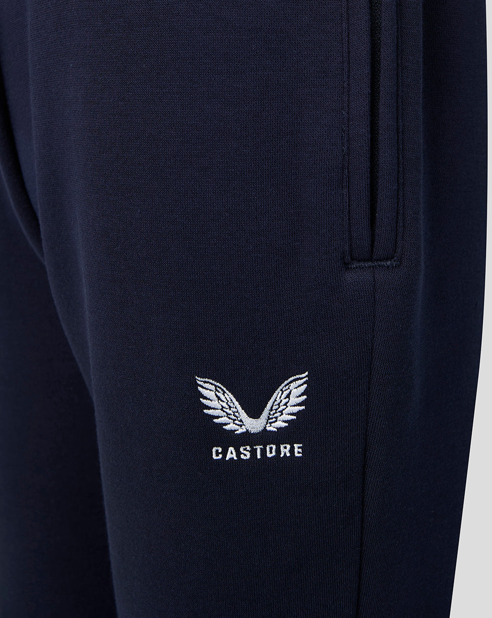 Close up of navy joggers featuring the white Castore emblem on the leg near the pocket.