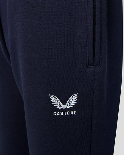 Close up of navy joggers featuring the white Castore emblem on the leg near the pocket.
