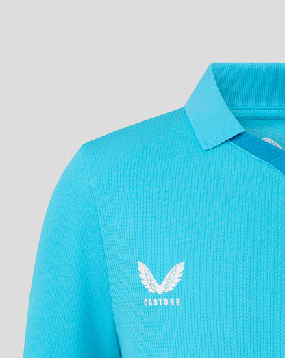Blue polo shirt with a visible brand logo on a light gray background