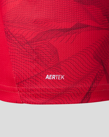 Close-up of a red athletic garment with a subtle dark wavy pattern and the white AERTEK logo near the hem.
