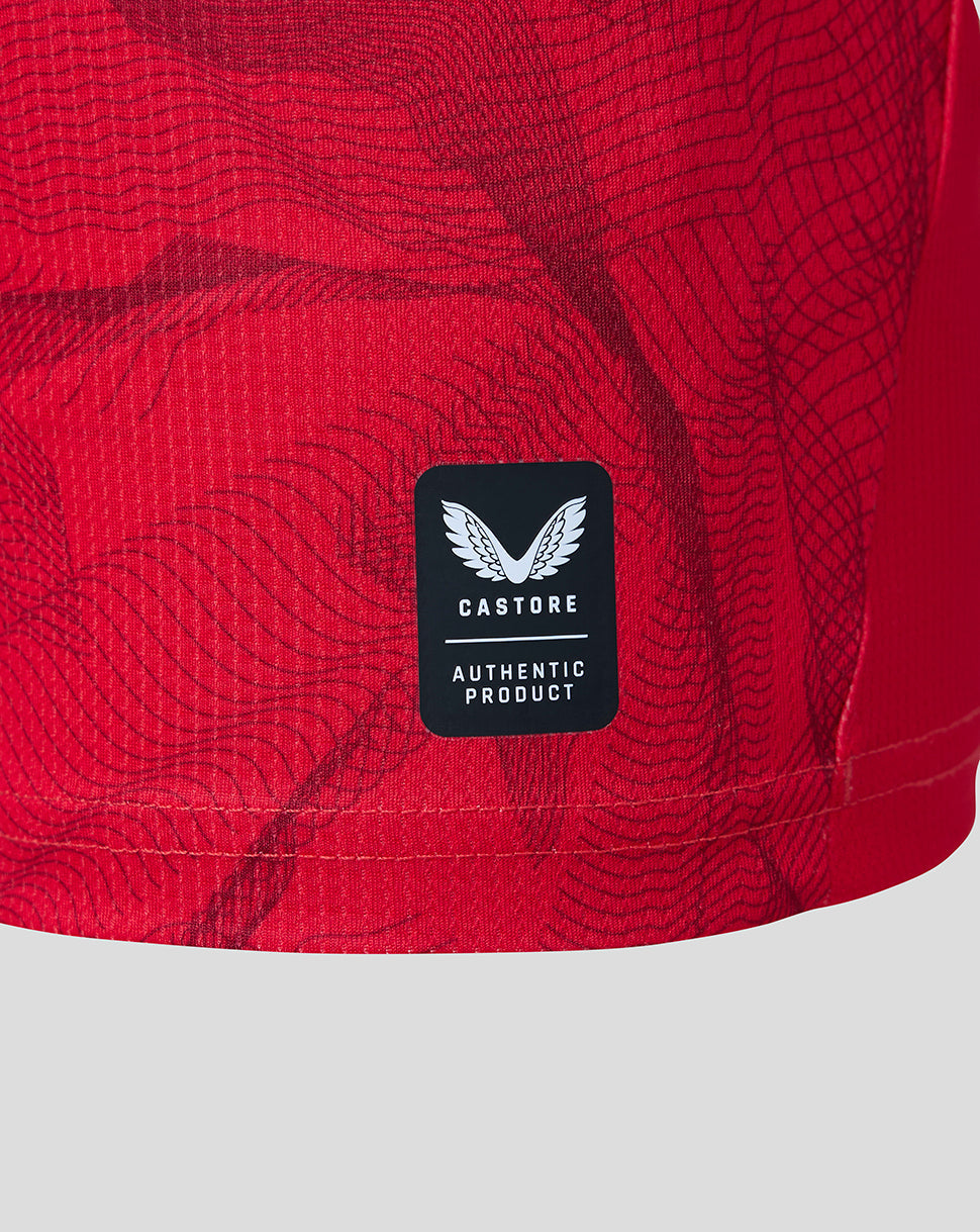 Close-up of the Preston North End Junior 26/27 third short sleeve shirt in Rococco Red with Castore authentic product patch on textured fabric