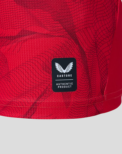 Close-up of the Preston North End Junior 26/27 third short sleeve shirt in Rococco Red with Castore authentic product patch on textured fabric