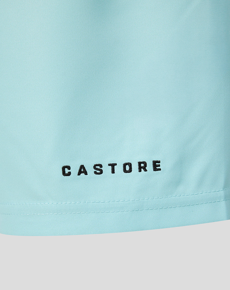 Close-up of a light pastel blue garment with the brand name 'CASTORE' printed in black across the lower front, above a stitched hem.
