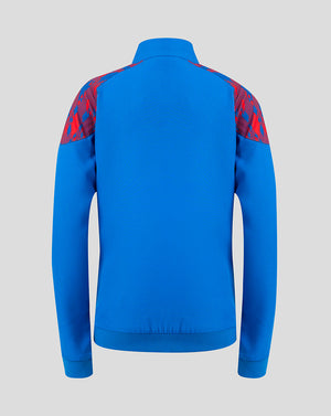 A bright blue long-sleeve athletic jacket shown from the back, featuring red patterned shoulder panels, on a solid light gray background.