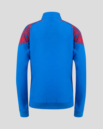 A bright blue long-sleeve athletic jacket shown from the back, featuring red patterned shoulder panels, on a solid light gray background.