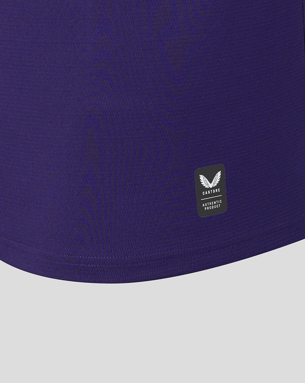 Close-up of a purple garment with a brand logo on a light gray background