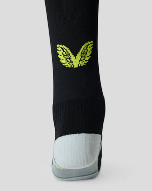 Close up of Bath Rugby Junior European Socks in black with a neon lime wing logo and a reinforced gray toe.