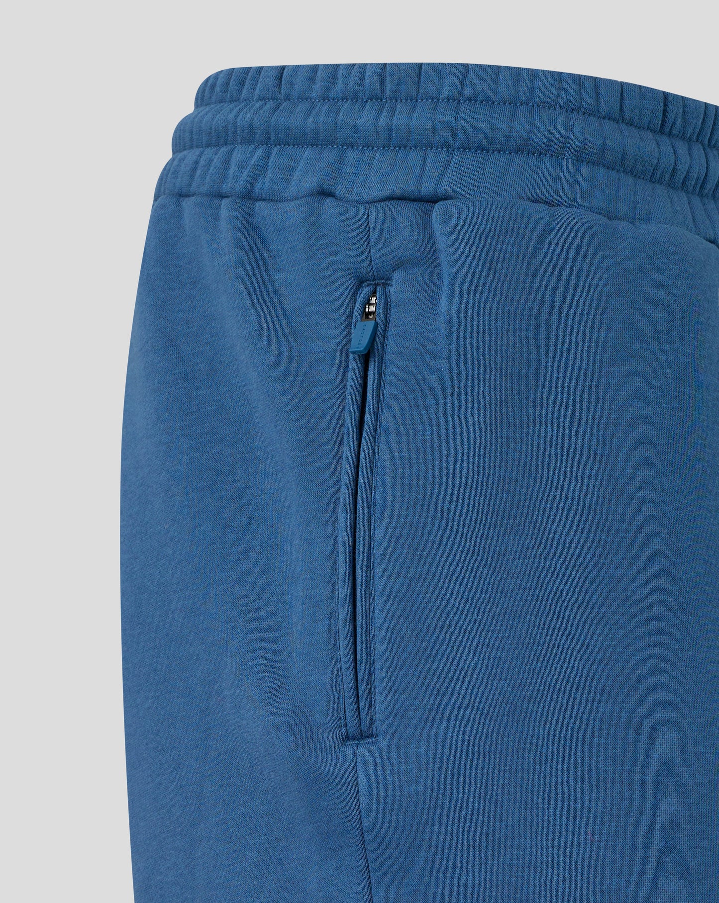 Blue sweatpants with a zipper on a light gray background
