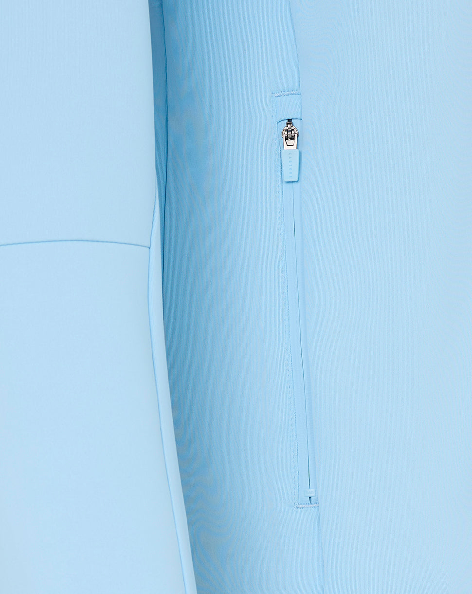 Close-up of a light blue jacket with a zipper detail on a white background