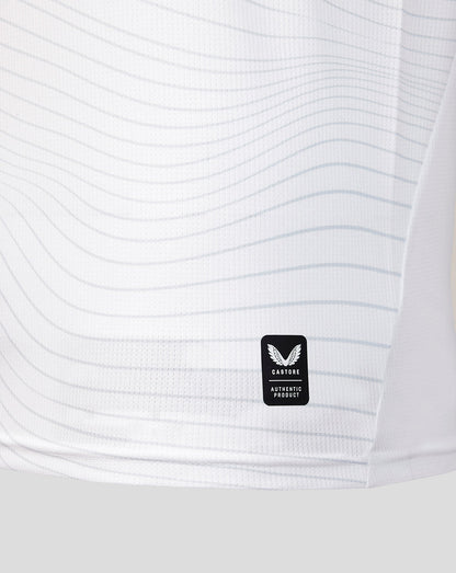 Close-up of a white textured shirt with a brand logo on a light gray background