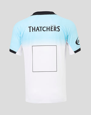 Back view of Bath Rugby away replica shirt with Thatchers branding across the upper back and light blue to white gradient.