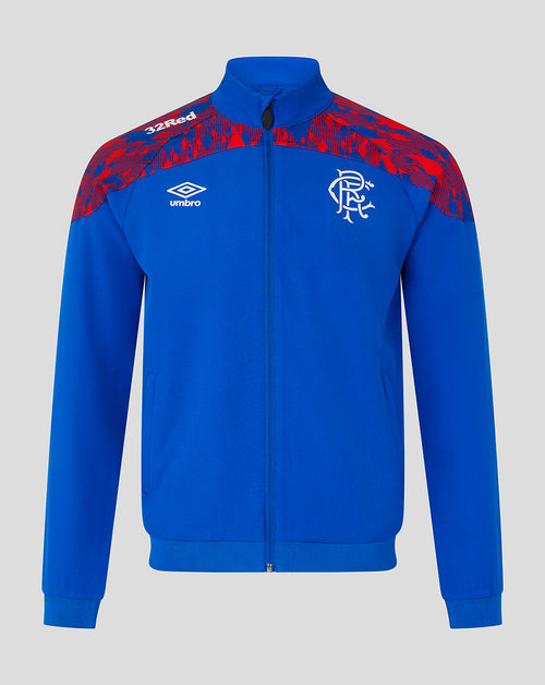 A royal blue track jacket with red patterned shoulder panels, featuring the Umbro logo and Rangers FC crest on the chest, displayed against a neutral gray background.