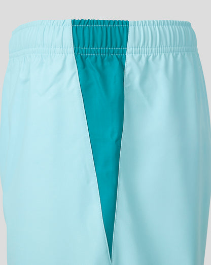 Close-up of athletic shorts in a very light icy blue with a contrasting teal vertical panel running down the center and a matching teal elastic waistband.