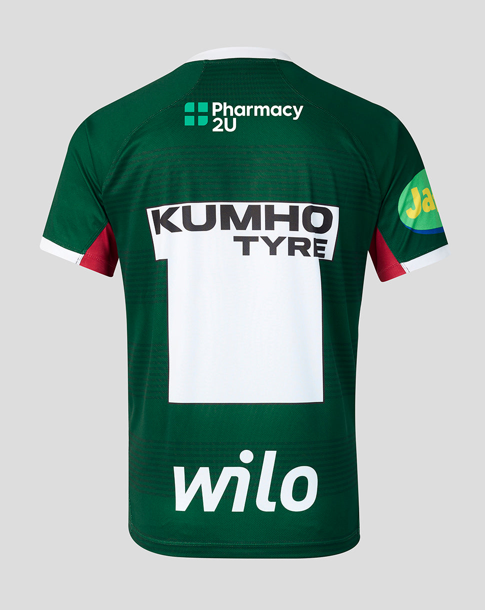 The back of a dark green sports jersey featuring sponsor logos including Wilo, Kumho Tyre, Pharmacy 2U on a light gray background.