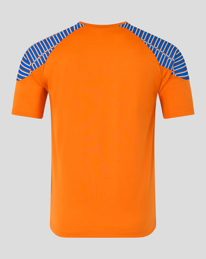 An orange short-sleeve athletic t-shirt with blue and white patterned raglan shoulder panels, shown against a solid gray background.