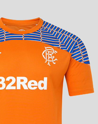 Close-up of an orange short-sleeve football jersey with blue and white patterned shoulder panels, a white Rangers crest on the chest, and partial white sponsor text reading 32Red.