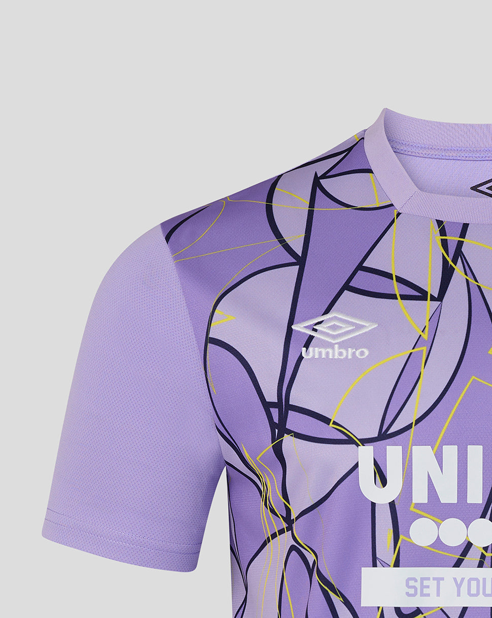 Close-up of a purple short-sleeve soccer jersey with an abstract line pattern in black and yellow, featuring the white Umbro logo on the chest.