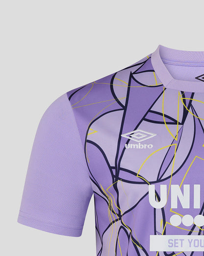Close-up of a purple short-sleeve soccer jersey with an abstract line pattern in black and yellow, featuring the white Umbro logo on the chest.