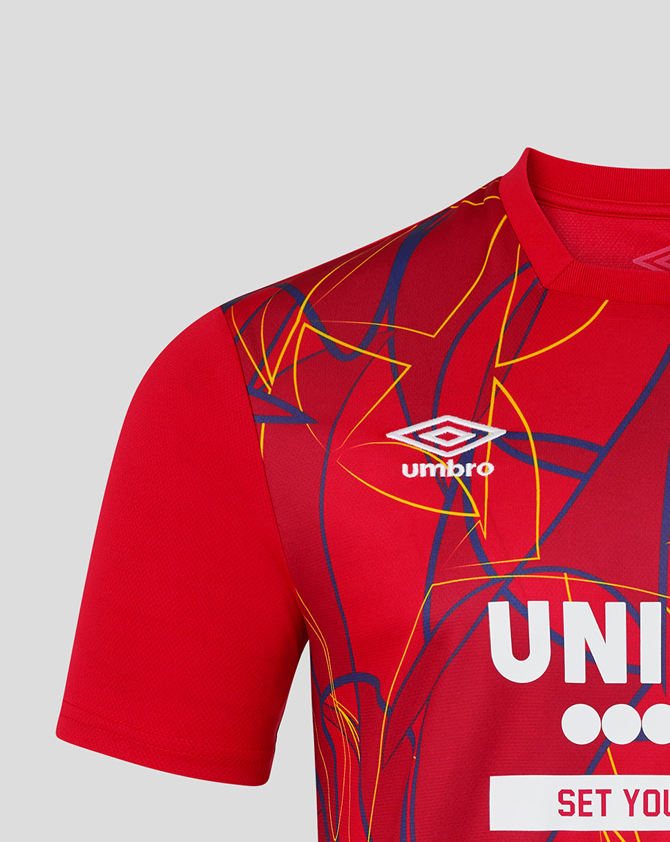 Red sports jersey with Umbro logo and abstract design on a gray background