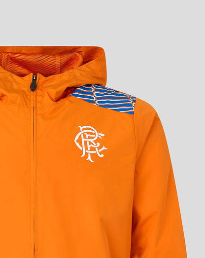 Close-up of an orange hooded jacket with a white stylized crest logo on the chest and a blue-and-white striped shoulder panel, shown against a light gray background.