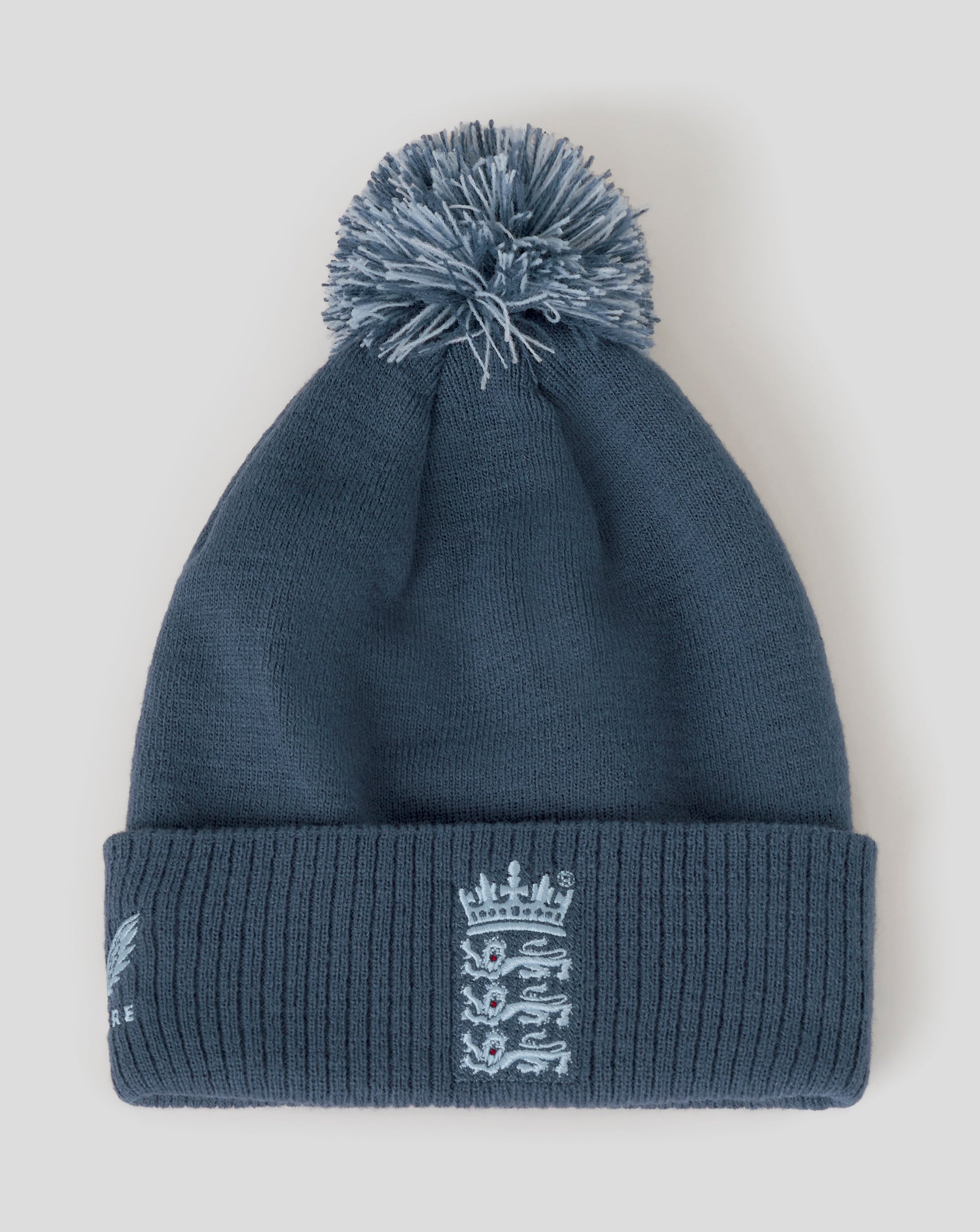 Blue knit beanie with pom-pom and logo on a light gray background
