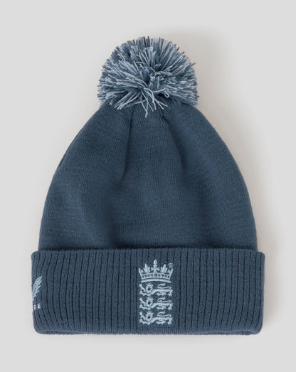 Blue knit beanie with pom-pom and logo on a light gray background