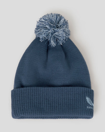 Blue beanie with pom-pom on a light gray background