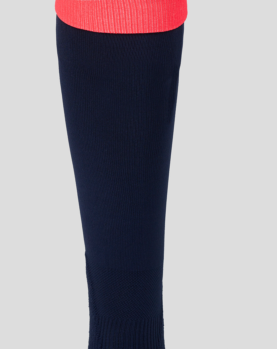 Navy blue knee-high sock with a red top on a light gray background