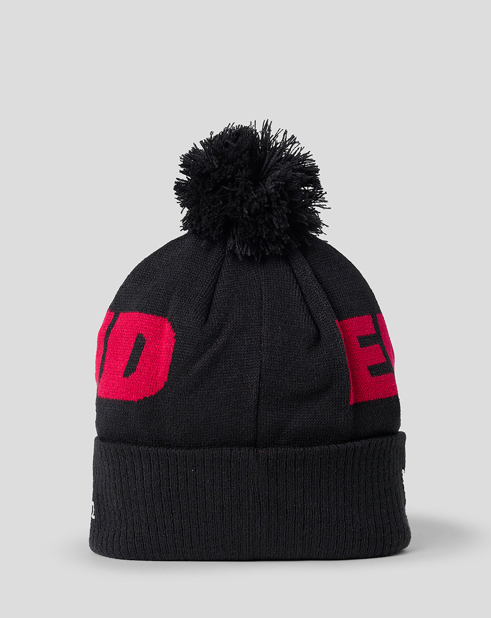 Black beanie with red logo on a light gray background