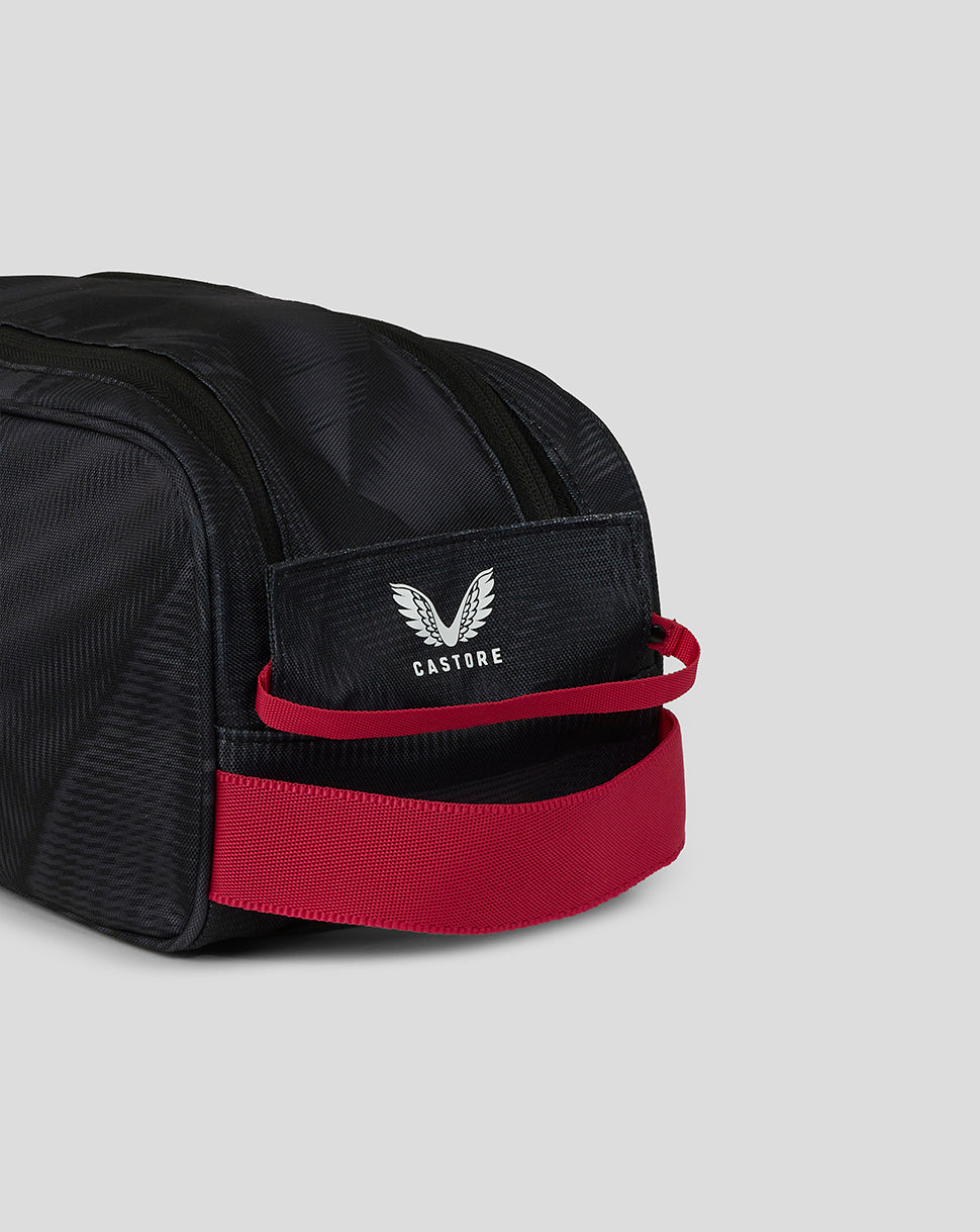 Black duffel bag with red accents and a visible brand logo on a light gray background