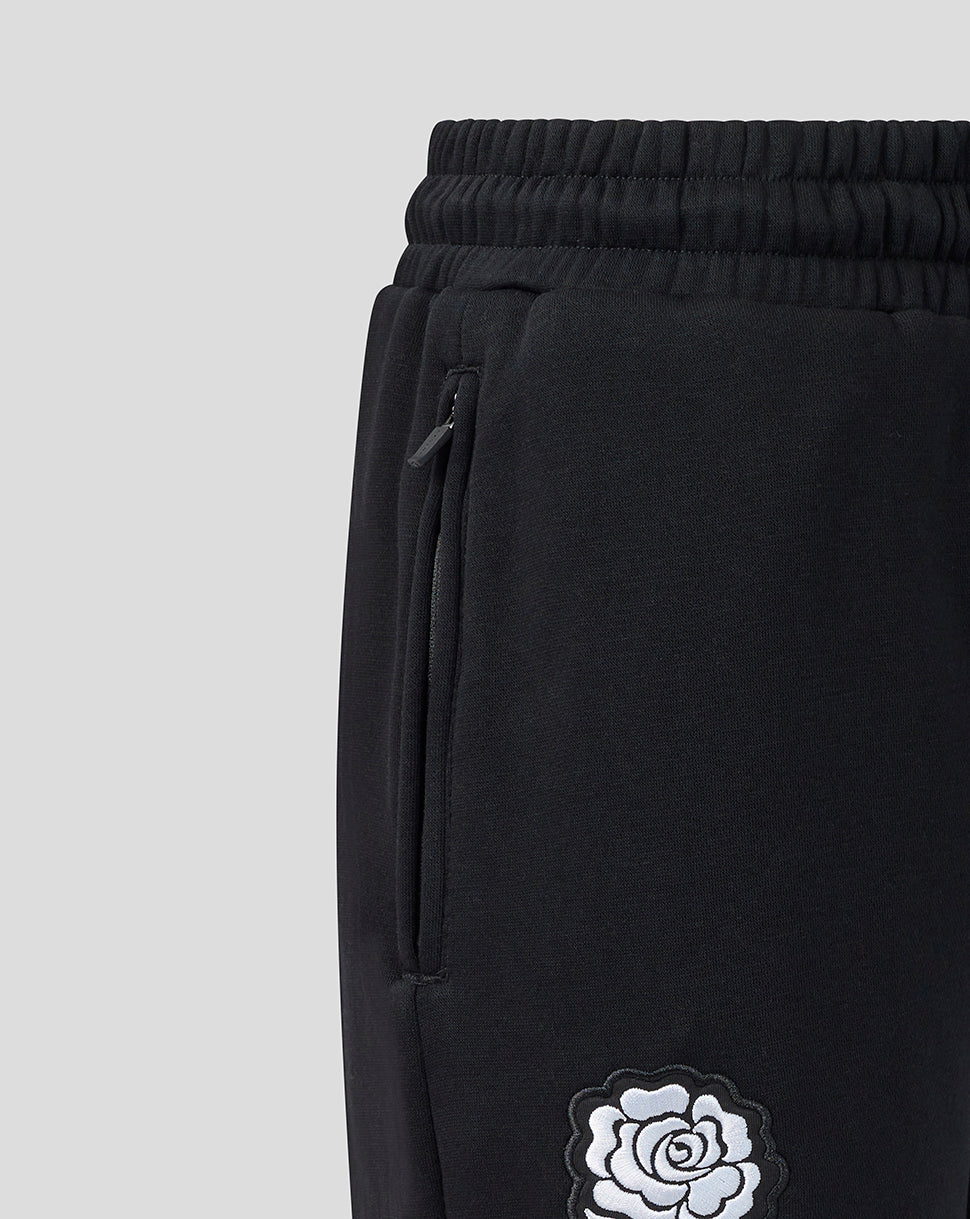 Black sweatpants with a white rose design on a light gray background