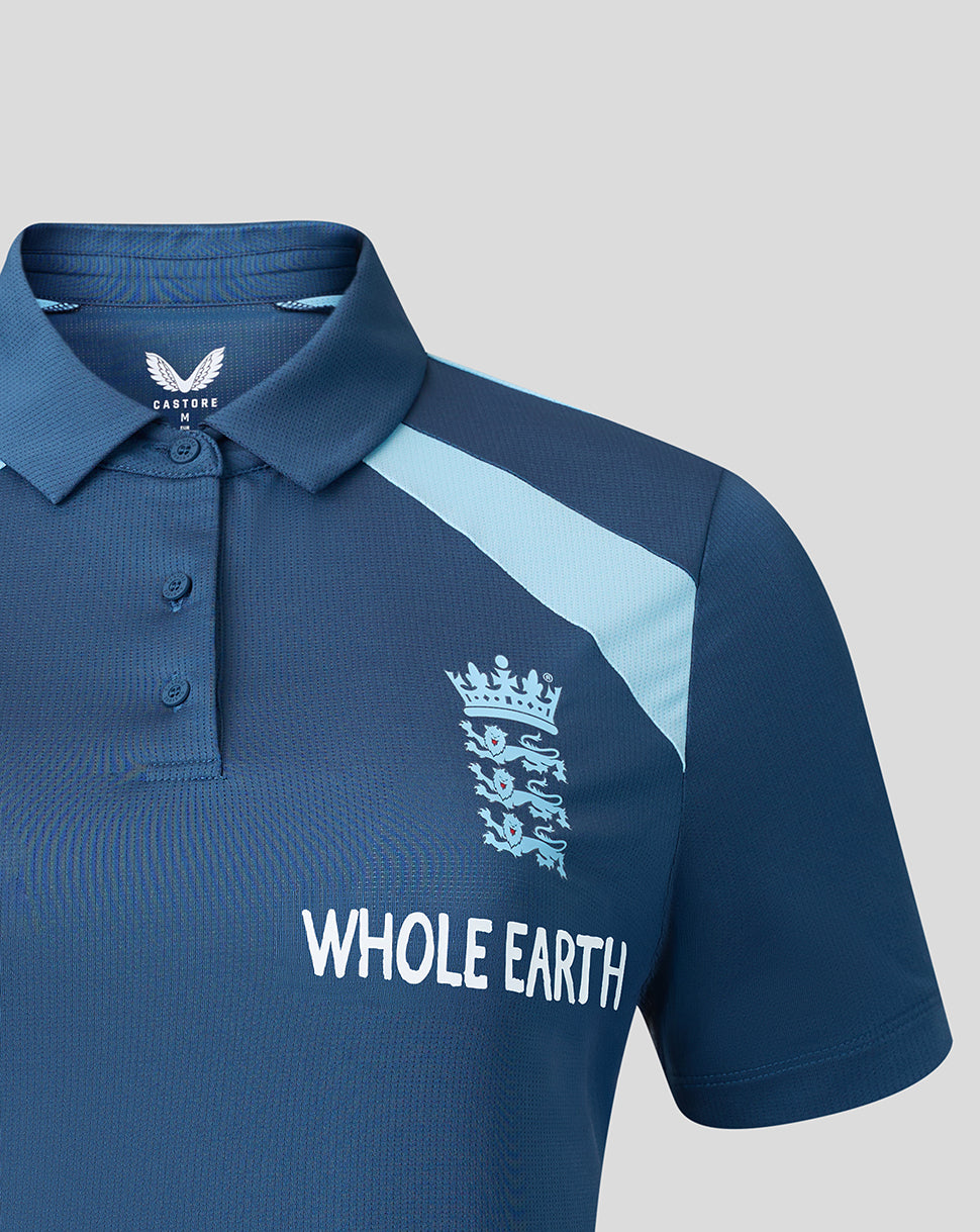 Blue polo shirt with 'Whole Earth' branding on a gray background