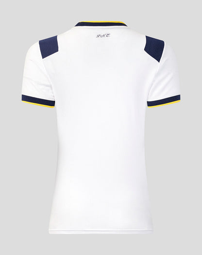 White sports jersey with navy and yellow accents on a gray background