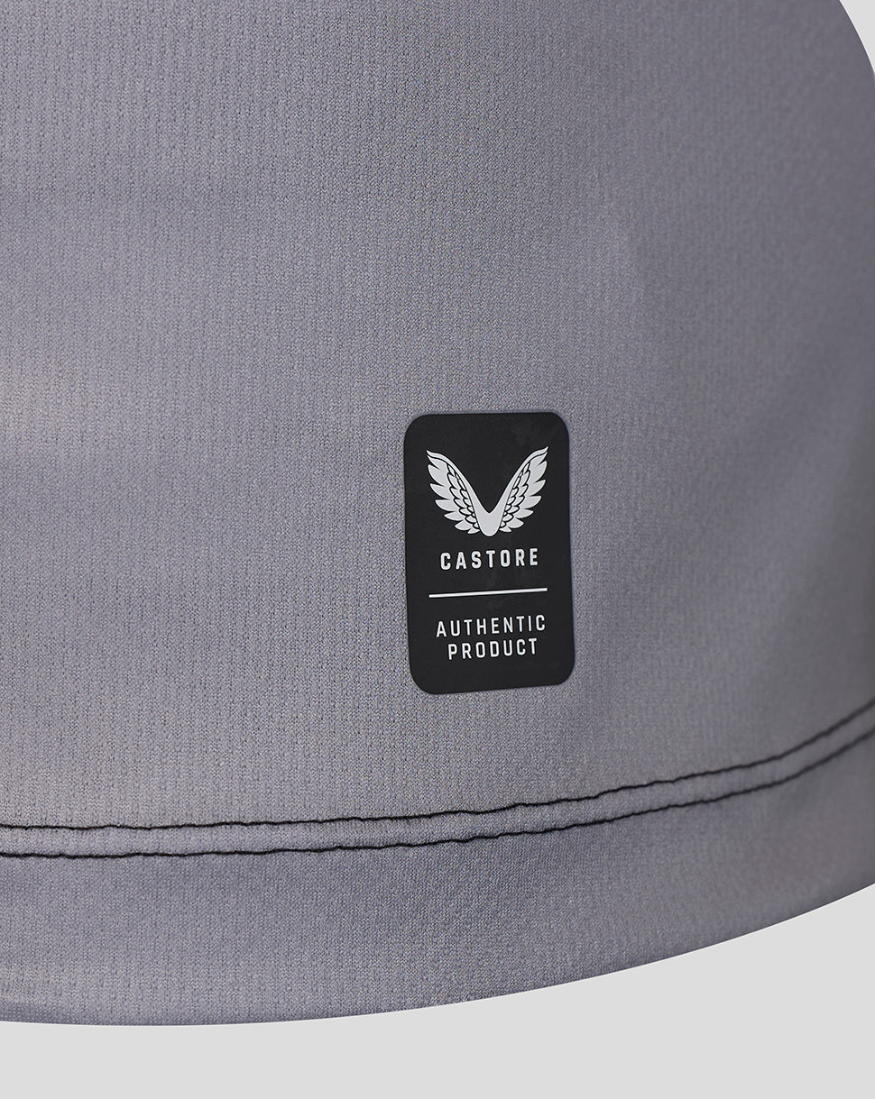 Close-up of a gray fabric product with a black rectangular patch featuring a white wing logo and the text 'CASTORE AUTHENTIC PRODUCT'.