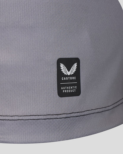 Close-up of a gray fabric product with a black rectangular patch featuring a white wing logo and the text 'CASTORE AUTHENTIC PRODUCT'.