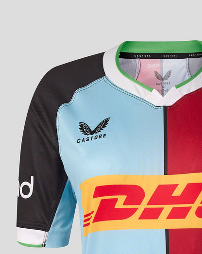 Close-up of a sports jersey with a color-blocked design featuring light blue, black, red, and yellow panels, with the Castore and DHL logos visible.