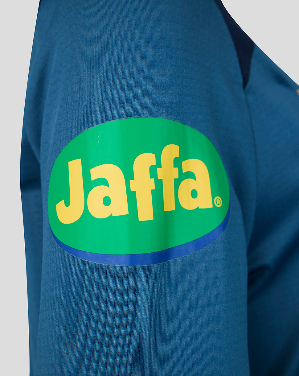 Sleeve of blue Leicester Tigers training top with large bright Jaffa logo patch in green and yellow.