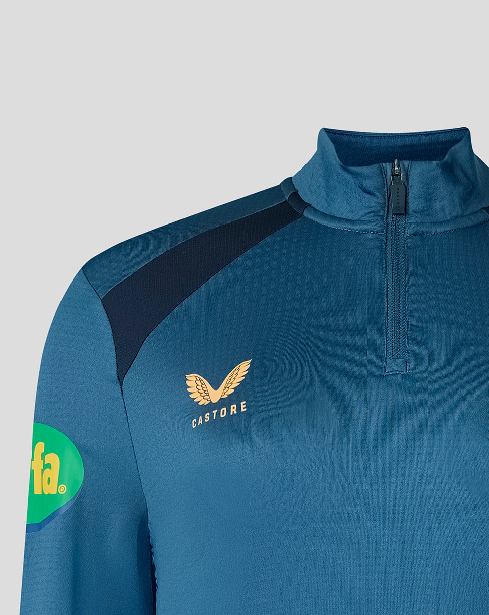 Shoulder close up of blue training top showing Breeden emblem and Castore branding.